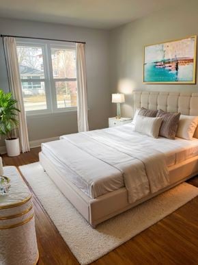 Cambridge apartment for rent - A bedroom with a large bed, a nightstand, and a painting on the wall.