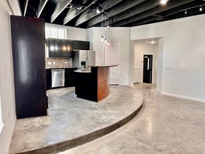 Houston apartment for rent - A kitchen area with a bar counter and a refrigerator.