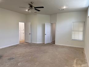 Houston apartment for rent - A room with a ceiling fan and three doors.