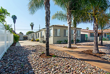 San Diego apartment for rent - A row of houses with palm trees in front.