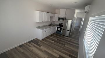 San Diego apartment for rent - A kitchen with white cabinets and a wooden floor.