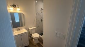 San Diego apartment for rent - A bathroom with a toilet, sink, and mirror.