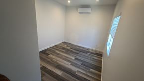 San Diego apartment for rent - A room with a wooden floor and a window on the right side.