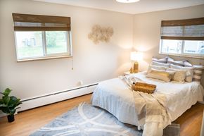 Lakewood apartment for rent - A bedroom with a large bed and a plant.