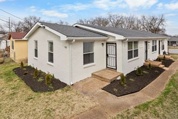 Nashville apartment for rent - A white house with a black door and a small front yard.