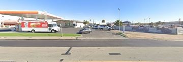 Chula Vista apartment for rent - A street view with a car and a truck in front of a gas station.