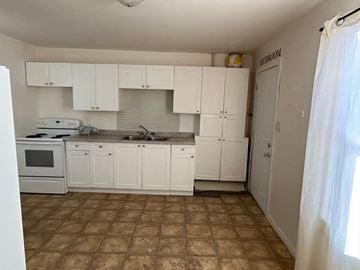 Prince Albert house for rent - A kitchen with white cabinets and a tiled floor.