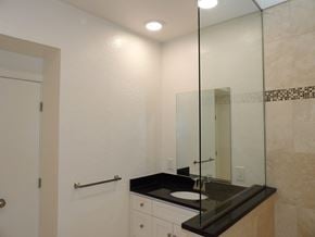 Dallas apartment for rent - A bathroom with a sink, mirror, and a door.