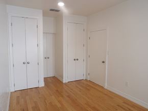 Dallas apartment for rent - A room with three white doors and wooden floors.