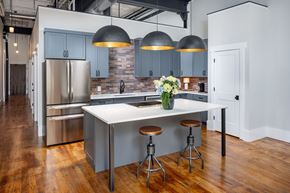 Monroe apartment for rent - A kitchen with a white island and a vase of flowers on it.