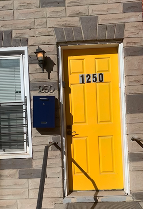 Baltimore house for rent - A yellow door with the number 1250 on it.
