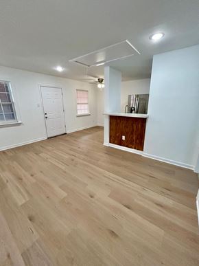 Houston apartment for rent - A room with wooden flooring and white walls.