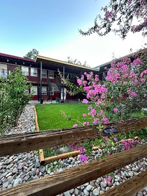 Houston apartment for rent - A building with a red roof and a wooden fence in front of it.