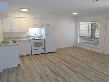 Dallas apartment for rent - A kitchen with white appliances and wooden floors.