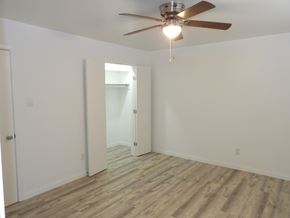 Dallas apartment for rent - A room with a ceiling fan and wooden flooring.