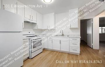 Escondido apartment for rent - A kitchen with white appliances and cabinets at 331 E Washington Ave.