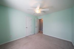 Phenix City house for rent - A room with a ceiling fan and two doors.