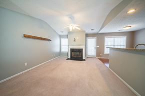 Phenix City house for rent - A living room with a fireplace and a ceiling fan.