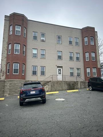 Fall River apartment for rent - A black SUV is parked in a parking lot in front of a building.