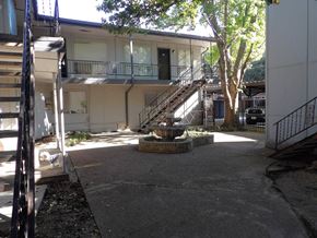 Dallas apartment for rent - A courtyard with a fountain and a tree.