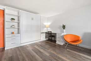 Honolulu apartment for rent - A room with a white desk, an orange chair, and a white cabinet with shelves.