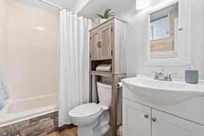 Honolulu apartment for rent - A white bathroom with a toilet, sink, and a cabinet.