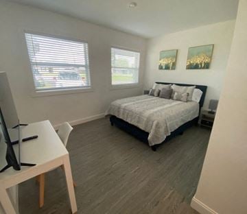 Mulberry apartment for rent - A bedroom with a bed, a desk, and two windows.