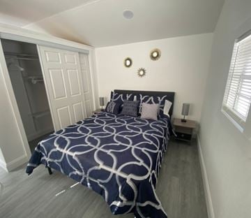 Lakeland apartment for rent - A bedroom with a bed, nightstand, and a wall clock.
