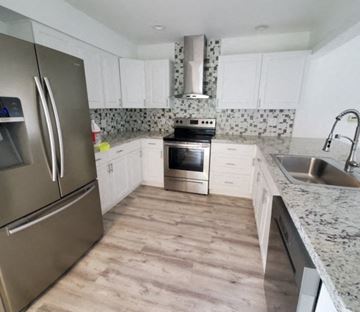 Lakeland apartment for rent - A kitchen with a stainless steel refrigerator and wooden flooring.