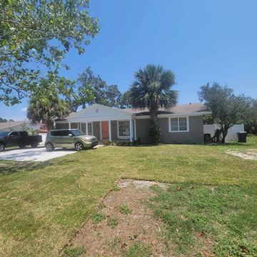 Lakeland apartment for rent - A house with a green lawn and a tree in front.