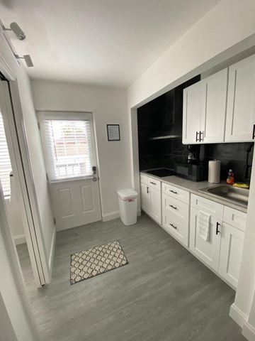 Lakeland apartment for rent - A kitchen with white cabinets and a window with blinds.