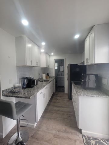 Lakeland apartment for rent - A kitchen with white cabinets and a granite countertop.