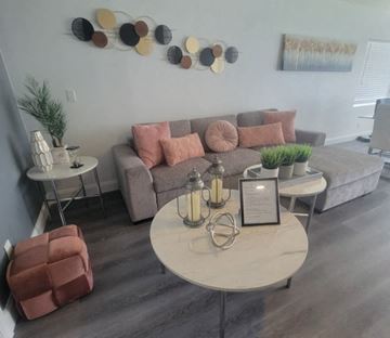 Lakeland apartment for rent - A living room with a grey couch, a white coffee table, and a wall art.