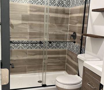Lakeland apartment for rent - A bathroom with a toilet, sink, and tiled shower.