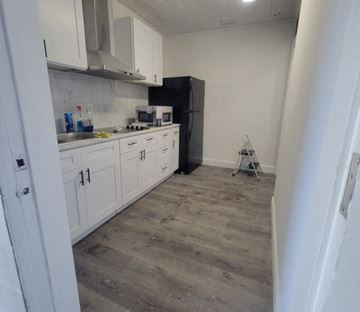 Lakeland apartment for rent - A kitchen with white cabinets and a black refrigerator.