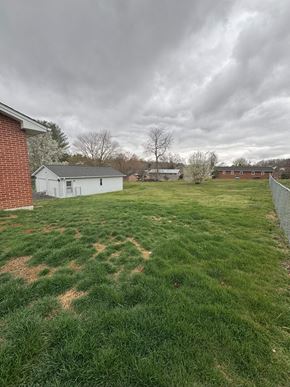 Johnson City house for rent - A white house with a red brick building behind it.