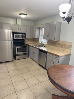 Johnson City house for rent - A kitchen with a refrigerator, oven, microwave, and sink.