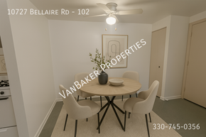 Cleveland apartment for rent - A dining room with a table and chairs and a phone number on the wall.