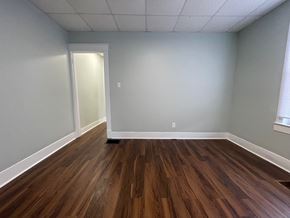 Louisville apartment for rent - A room with wooden flooring and a doorway leading to another room.