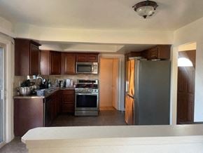 Santa Maria house for rent - A kitchen with brown cabinets and a stove top oven.