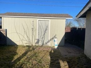 Santa Maria house for rent - A small building with a door and a window is surrounded by a grassy area.