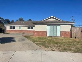 Santa Maria house for rent - A house with a grey roof and a brick wall.