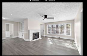 Fayetteville house for rent - A spacious living room with a fireplace and a ceiling fan.