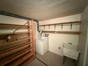 Fort Collins apartment for rent - A laundry room with a washer and dryer, a sink, and a set of stairs.