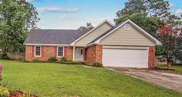 Fayetteville house for rent - A house with a red brick wall and a white garage door.