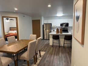 Hawarden apartment for rent - A kitchen with a table and chairs in the foreground and a refrigerator in the background.