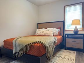 Hawarden apartment for rent - A bedroom with a bed, nightstand, and window.