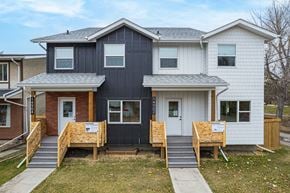 Edmonton apartment for rent - A house with a black and white exterior is shown with boarded up windows.