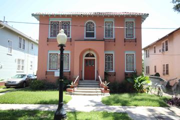 New Orleans apartment for rent - A pink house with a black lamp post in front.