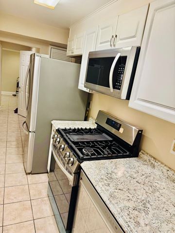 Washington apartment for rent - A kitchen with a stove, refrigerator, and microwave.